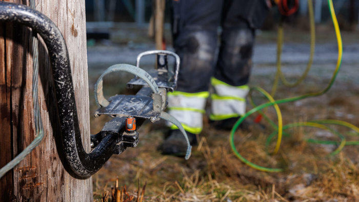 Stolpesko festet til strømstolpe med et menneske som nærmer seg i bakgrunnen.